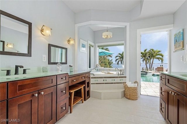 bathroom featuring a garden tub, vanity, and tile patterned floors