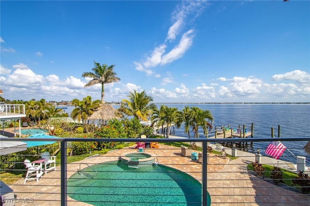 surrounding community featuring a water view and a hot tub