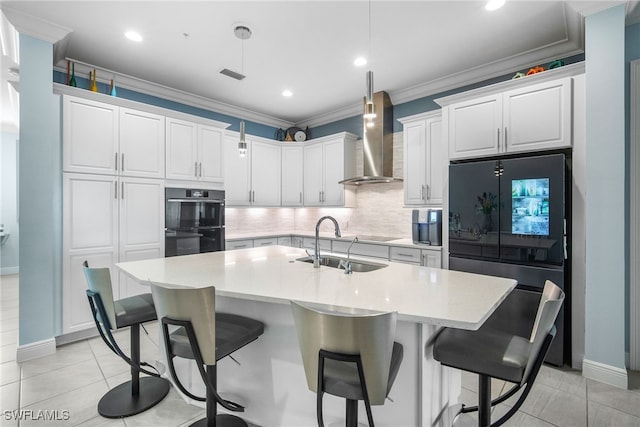 kitchen with sink, white cabinetry, black appliances, ornamental molding, and wall chimney range hood