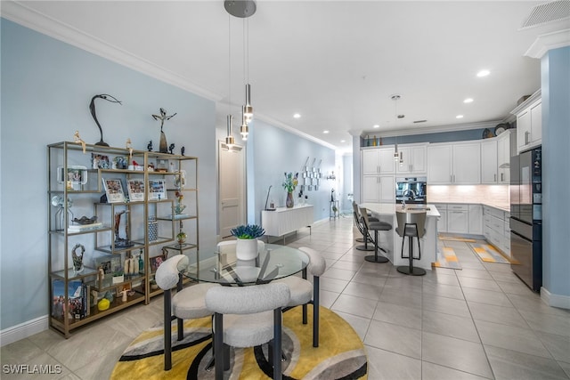 dining area featuring sink, ornamental molding, and light tile patterned flooring