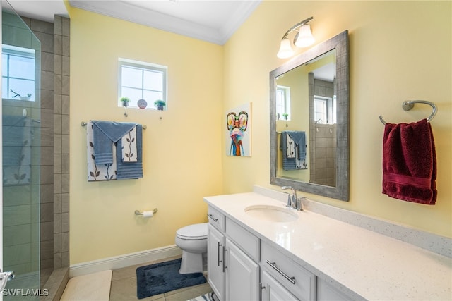 bathroom with crown molding, tile patterned flooring, vanity, a tile shower, and toilet