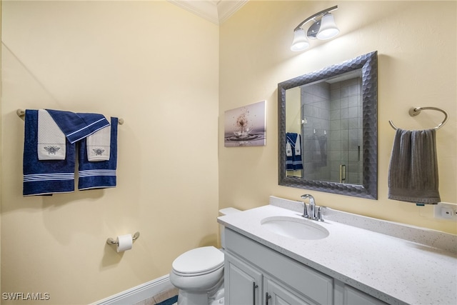 bathroom with an enclosed shower, vanity, crown molding, and toilet