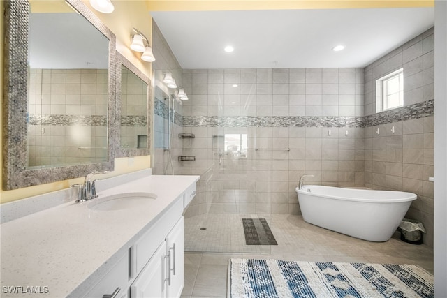 bathroom with tile patterned flooring, vanity, separate shower and tub, and tile walls