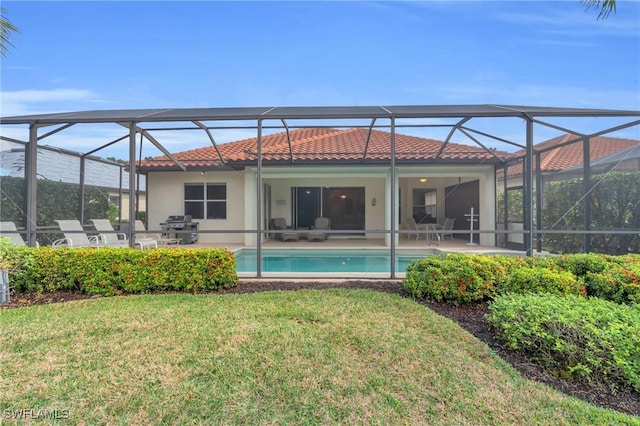 back of house featuring a yard, a patio area, and glass enclosure