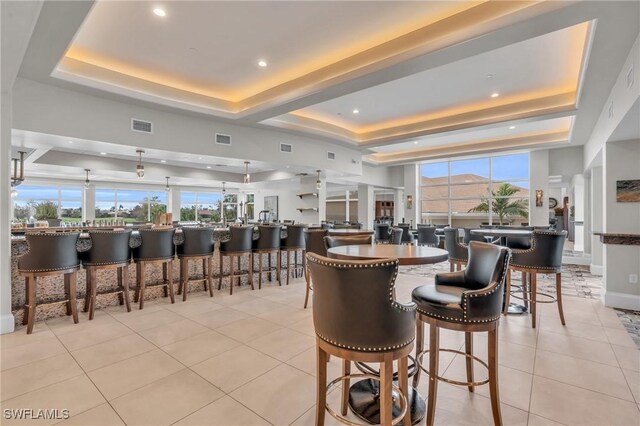 12560 Wildcat Cove Cir, Estero, FL 33928 - dining area with a raised ceiling, light tile patterned floors, a community bar, recessed lighting, and baseboards