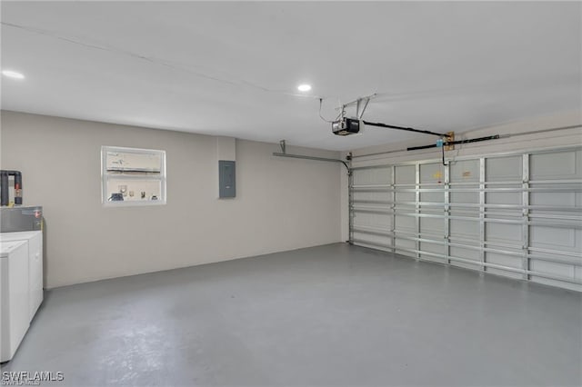 garage featuring a garage door opener, electric panel, and independent washer and dryer