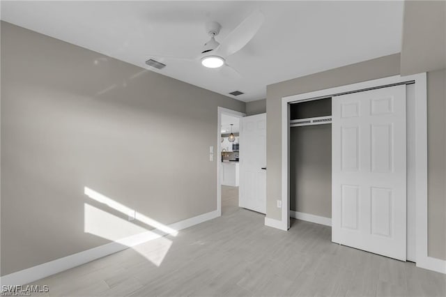 unfurnished bedroom featuring light hardwood / wood-style floors, a closet, and ceiling fan