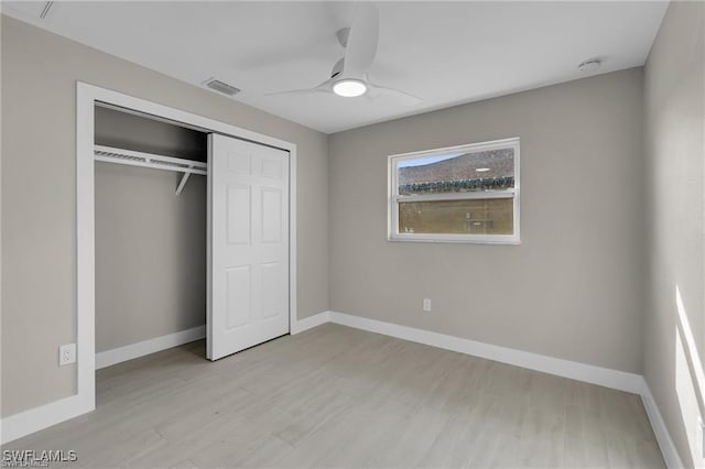 unfurnished bedroom with ceiling fan, light hardwood / wood-style floors, and a closet