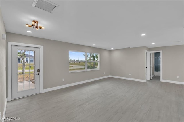 empty room featuring plenty of natural light and light hardwood / wood-style floors