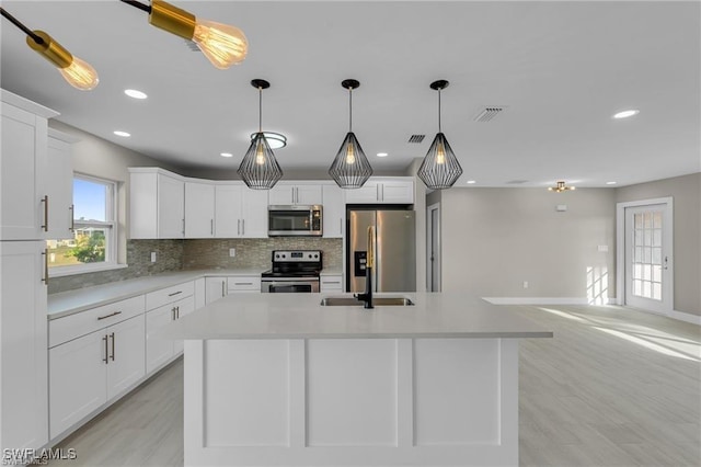 kitchen featuring stainless steel appliances, a kitchen island, and white cabinets