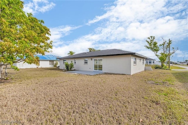 back of property with a yard and a patio area