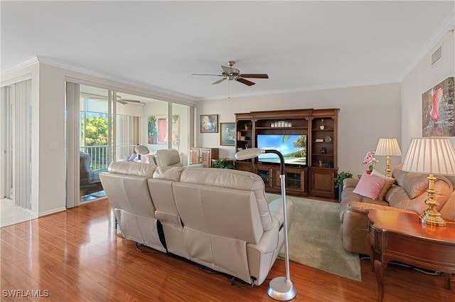 living room featuring crown molding, ceiling fan, and light hardwood / wood-style floors