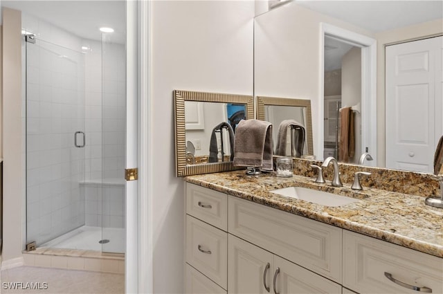 bathroom featuring vanity and a shower with door