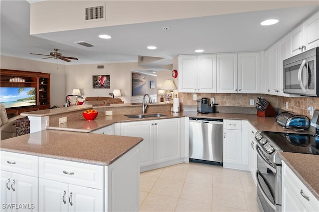 kitchen featuring white cabinetry, appliances with stainless steel finishes, kitchen peninsula, and sink