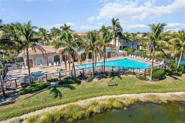 view of swimming pool with a patio, a water view, and a lawn