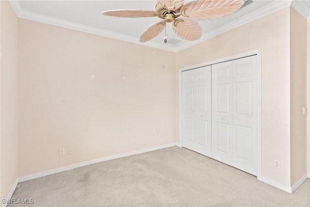 unfurnished bedroom featuring light carpet, ornamental molding, a closet, and ceiling fan