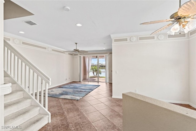 tiled entrance foyer with crown molding and ceiling fan