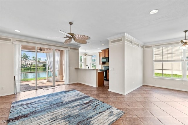 unfurnished living room featuring ornamental molding, a water view, a healthy amount of sunlight, and ceiling fan