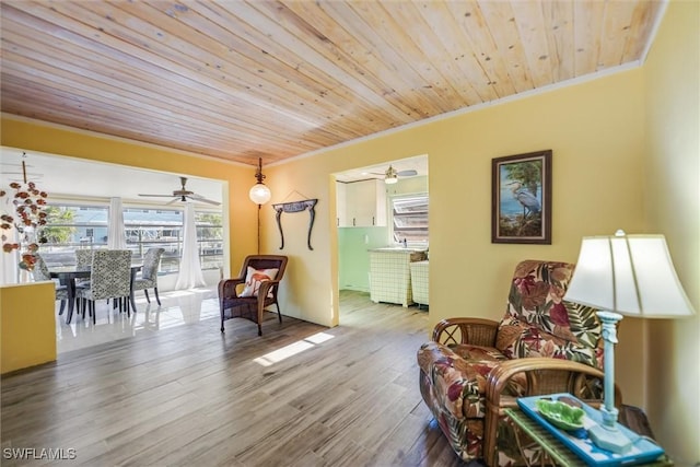 sitting room with wood ceiling, ornamental molding, and hardwood / wood-style floors