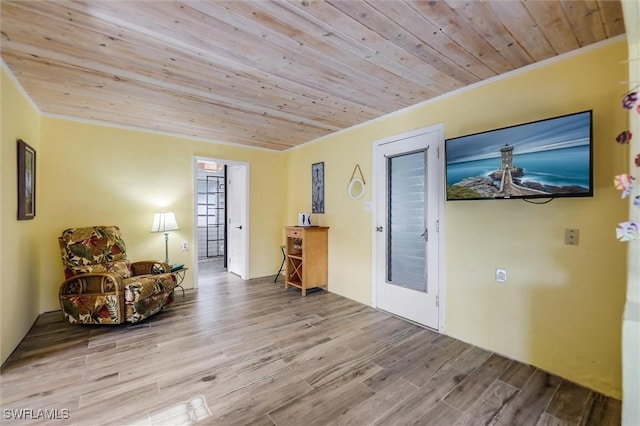 living area with wood ceiling, ornamental molding, and light wood-type flooring