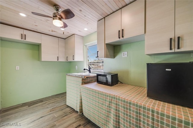 kitchen featuring tile countertops, sink, ceiling fan, wooden ceiling, and light wood-type flooring