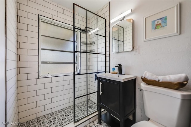 bathroom with vanity, toilet, and a tile shower