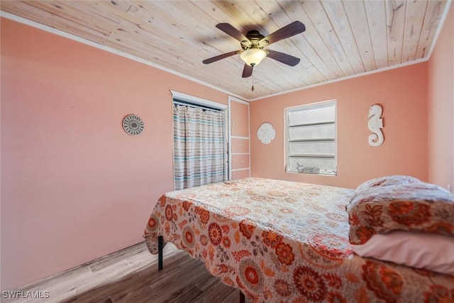 bedroom with ceiling fan, ornamental molding, wooden ceiling, and light wood-type flooring