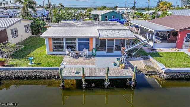 rear view of property with a water view, a patio, a sunroom, and a lawn