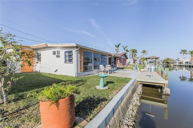 back of house with a water view, a yard, and a patio area