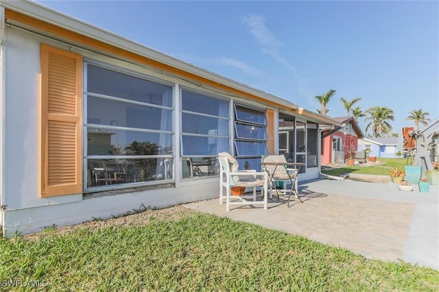 back of property with a yard and a patio