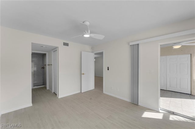 unfurnished bedroom with ensuite bath, ceiling fan, and light wood-type flooring