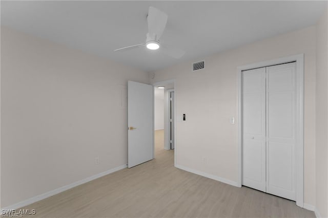 unfurnished bedroom with light hardwood / wood-style floors, a closet, and ceiling fan