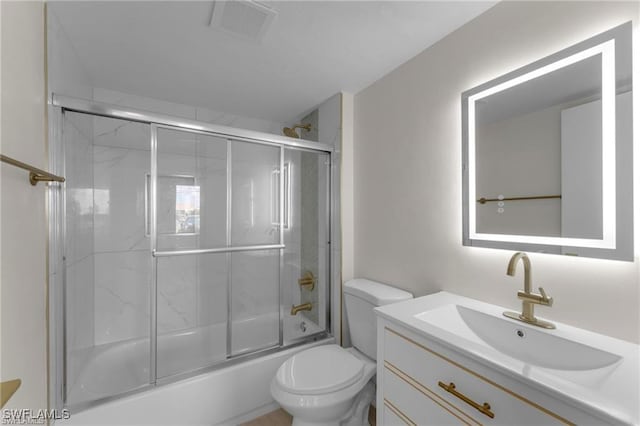 full bathroom with vanity, bath / shower combo with glass door, and toilet