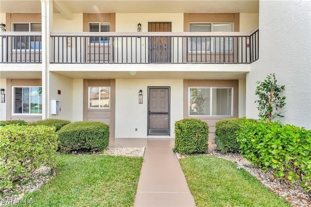 view of exterior entry with a balcony