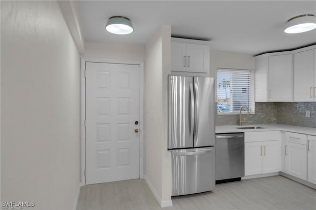 kitchen featuring tasteful backsplash, appliances with stainless steel finishes, sink, and white cabinets