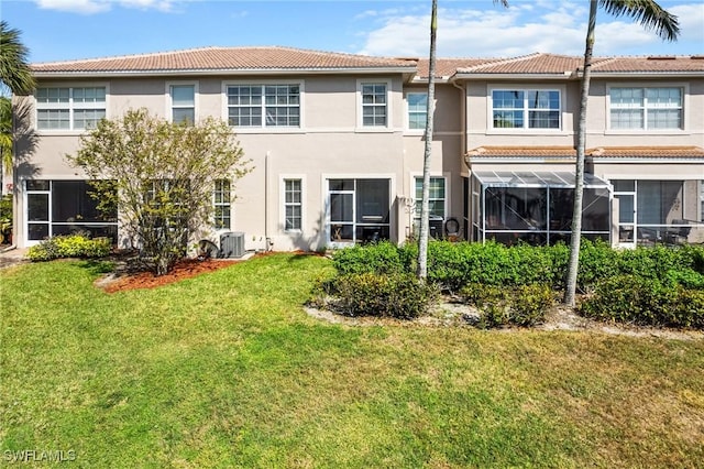 rear view of property with cooling unit and a yard