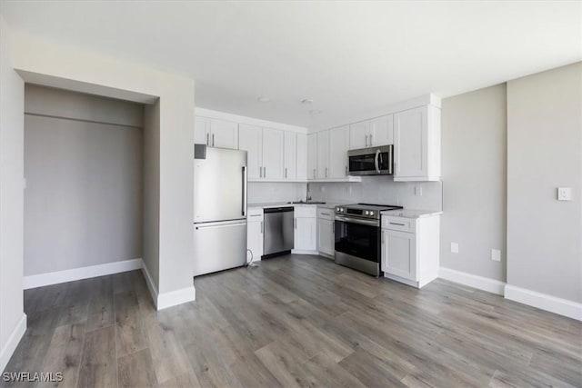 kitchen with light hardwood / wood-style floors, white cabinets, and appliances with stainless steel finishes