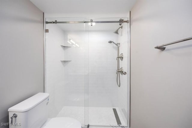 bathroom with a shower with door and toilet