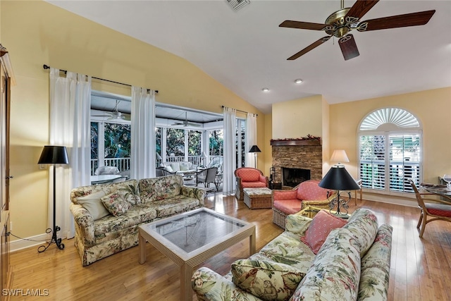 living room with lofted ceiling, a fireplace, light hardwood / wood-style floors, and ceiling fan