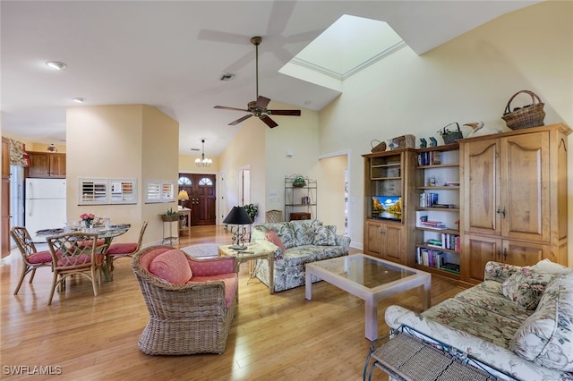 living room featuring ceiling fan with notable chandelier, high vaulted ceiling, and light hardwood / wood-style flooring