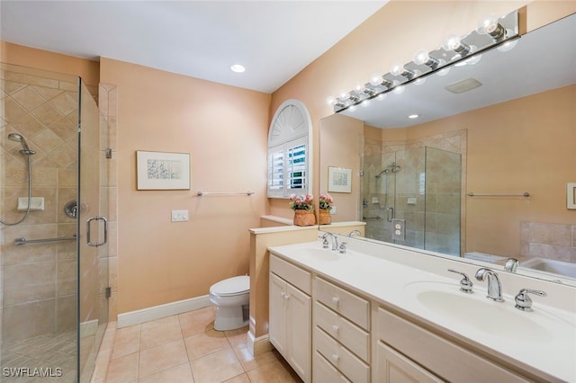 bathroom with tile patterned flooring, vanity, a shower with door, and toilet