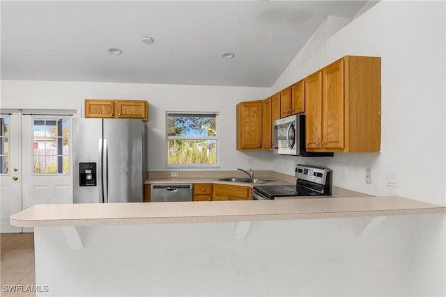 kitchen with a sink, plenty of natural light, appliances with stainless steel finishes, a peninsula, and light countertops