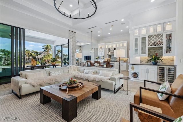 living room featuring crown molding, bar area, wine cooler, and light wood-type flooring