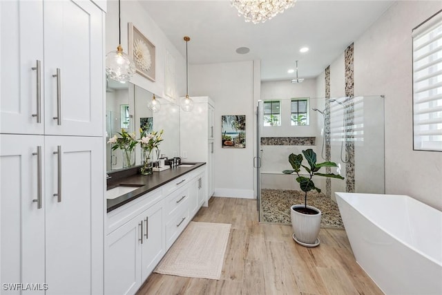 bathroom featuring independent shower and bath, vanity, and hardwood / wood-style flooring