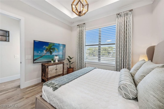 bedroom featuring an inviting chandelier and light wood-type flooring