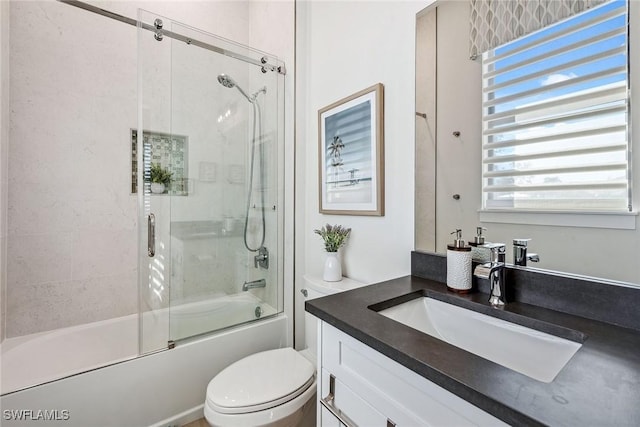 full bathroom featuring vanity, enclosed tub / shower combo, and toilet