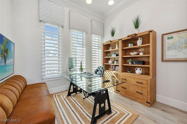 home office with crown molding and light hardwood / wood-style floors