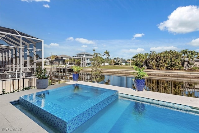 view of swimming pool featuring an in ground hot tub, a water view, and glass enclosure