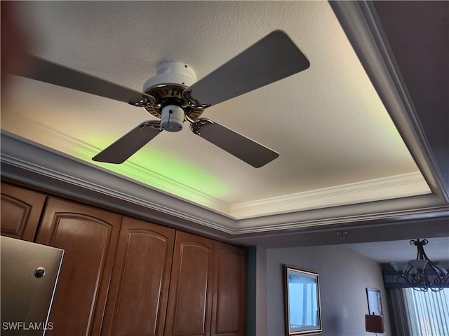 interior details with crown molding and ceiling fan with notable chandelier