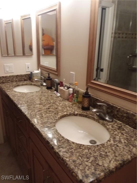 bathroom with vanity and tiled shower